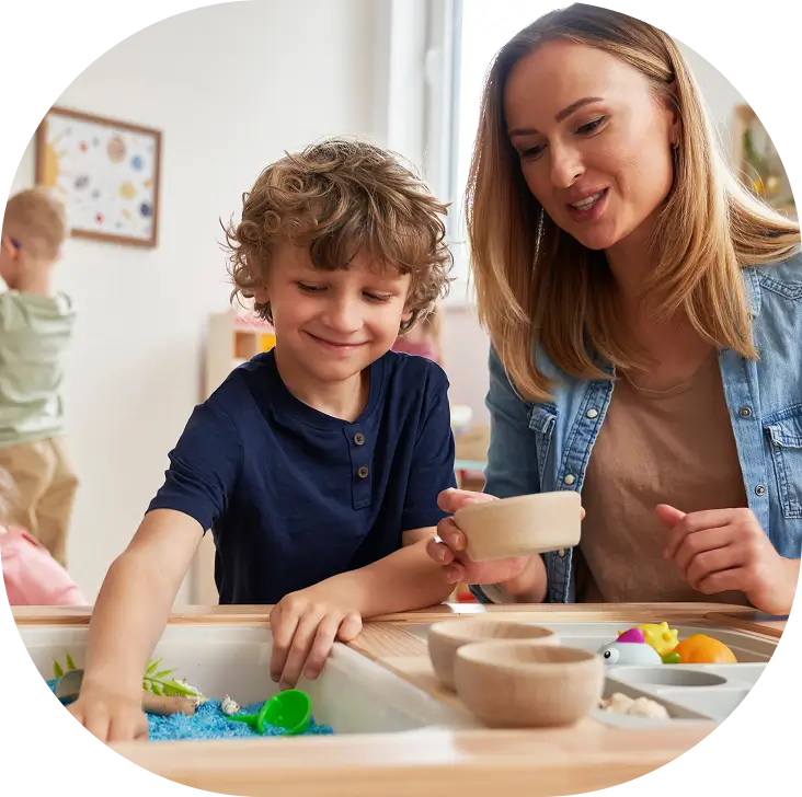 Child and adult playing with sensory toys.